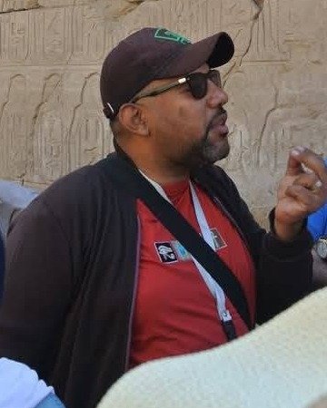 Hany Ashour explaining a carved temple wall to his group in Luxor