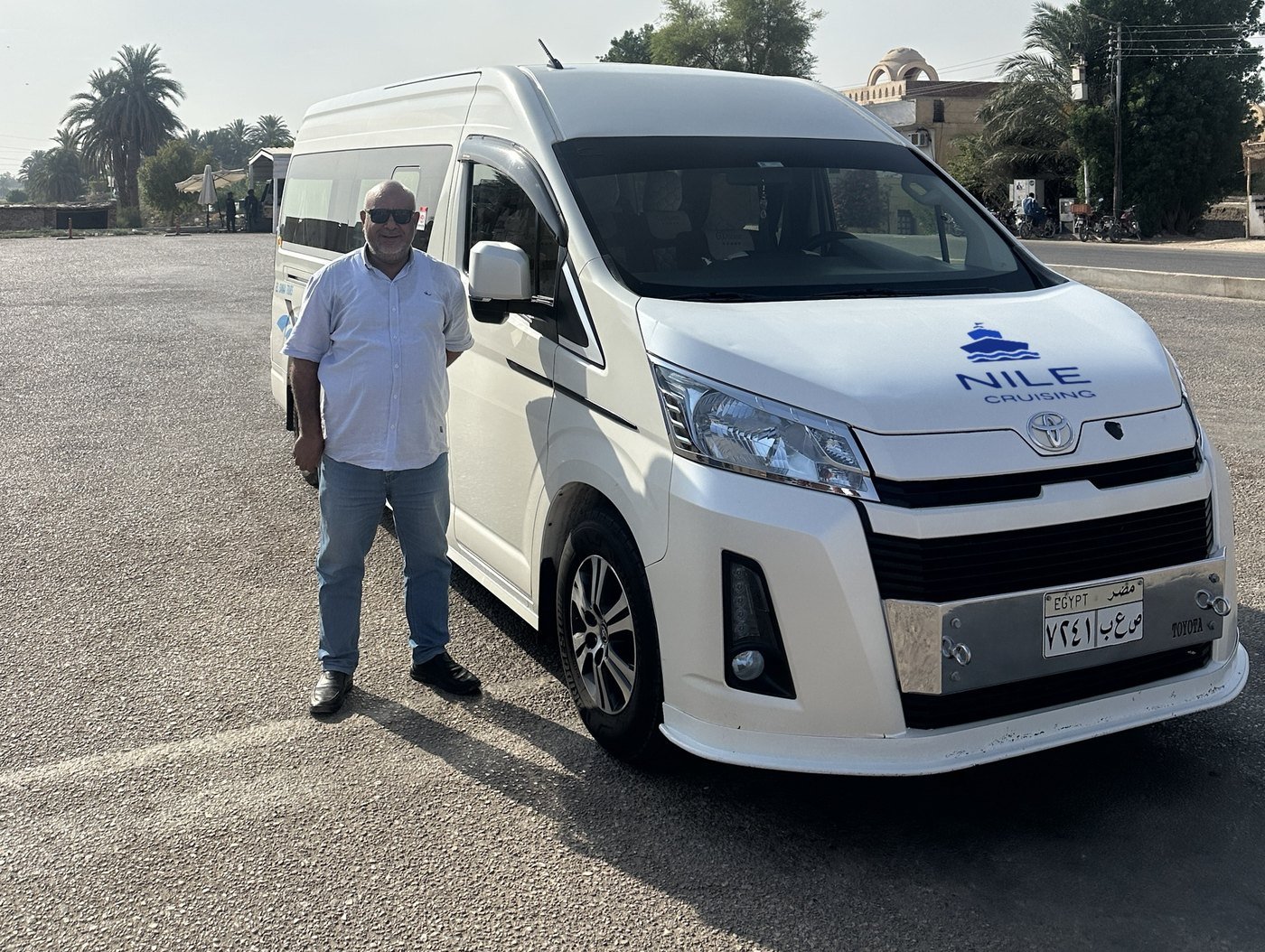 Talat, head of the drivers at Nile Cruising, standing beside one of the company minibuses in Luxor